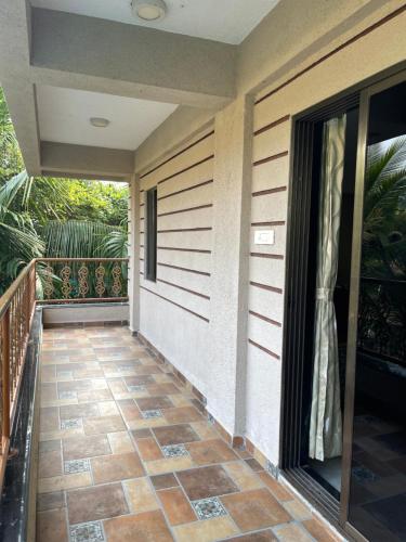a porch of a house with a tile floor at Neville's Villa - Pet friendly with Pool in Alibaug