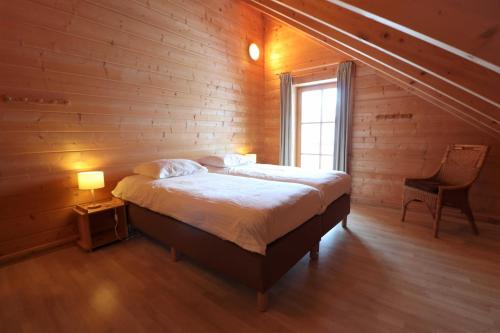a bedroom with a bed in a wooden wall at Vakantiehuis Luxe BlokhuisA in Willingen