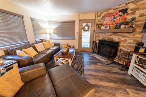 a living room with a couch and a fireplace at Giant Steps 12 Rustic Retreat ski in out in Brian Head