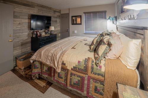 a bedroom with a bed and a television in it at Giant Steps 12 Rustic Retreat ski in out in Brian Head