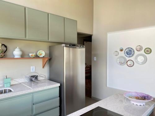 a kitchen with a stainless steel refrigerator with plates on the wall at Apto temático Pintura e Porcelana Centro Pomerode in Pomerode