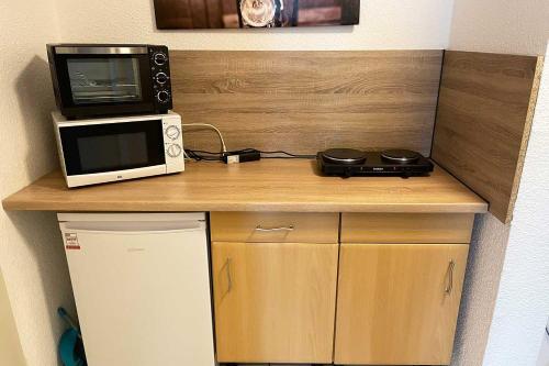 a small kitchen with a microwave and a microwave at Ferienwohnung Köln Junkersdorf in Cologne