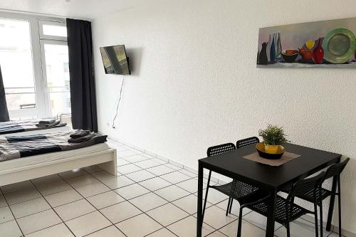 ein Wohnzimmer mit einem Tisch, Stühlen und einem Bett in der Unterkunft Ferienwohnung Köln Junkersdorf in Köln