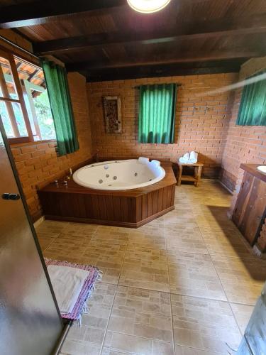 a large bathroom with a large tub in a room at Chalés de Analuz in Visconde De Maua
