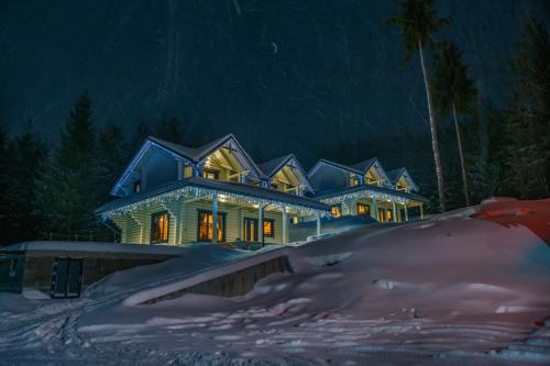 a house in the snow at night at WhiteWood Cottages in Bukovel