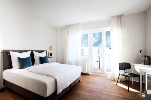 um quarto branco com uma cama e uma secretária em SAXX Apartments Hagen em Hagen