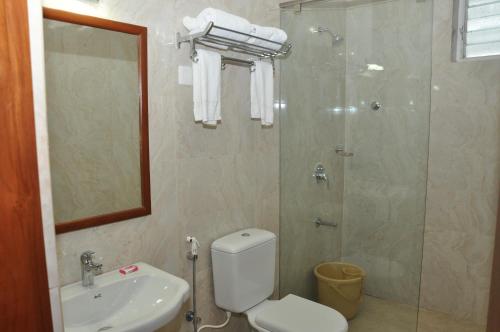 a bathroom with a shower and a toilet and a sink at Hotel Royal Chambers in Coimbatore