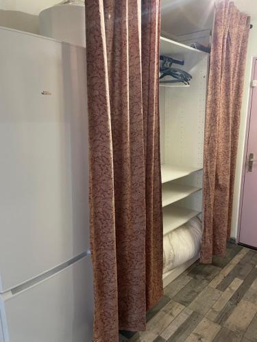 armadio con tende marroni in camera di Les Oliviers a Balaruc-les-Bains