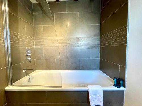 a bath tub in a bathroom with a shower at The Crook in Stow on the Wold