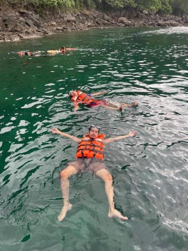 a group of people swimming in the water at KOOK BUNGALOW in Koh Mook