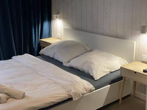 a large white bed with two pillows on it at Villa Vincentów in Myślenice