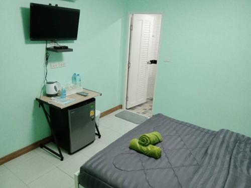 a bedroom with a bed with green towels on it at KOOK BUNGALOW in Koh Mook