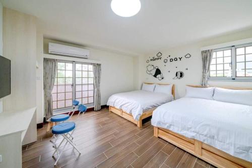 1 Schlafzimmer mit 2 Betten und 2 Stühlen in der Unterkunft 湯姆熊休閒會館 in T'ien-liao
