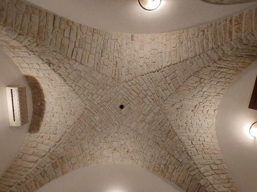 um quarto com um tecto de pedra com luzes em Soggiornare In Centro em Alberobello