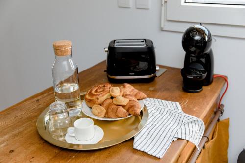 - une table avec une assiette de pain et une bouteille de vin dans l'établissement Magnifique appartement 50m2 aux portes de Nantes, à Vertou
