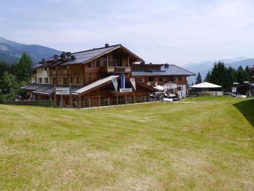 a large wooden house on top of a grass field at Panorama Chalet in Mittersill