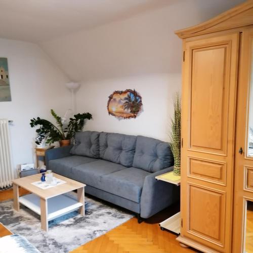 a living room with a blue couch and a table at Apartment Schloffer in Weiz