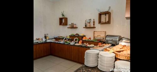 a kitchen with a counter with plates and a sink at kristal otel adana in Adana