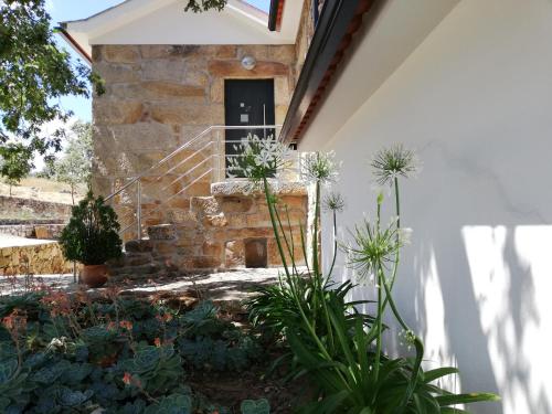 a courtyard with plants in front of a building at Quinta dos Carvalhais - Serra da Estrela in Fornos de Algodres