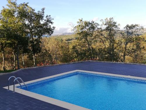 a swimming pool on the side of a house at Quinta dos Carvalhais - Serra da Estrela in Fornos de Algodres