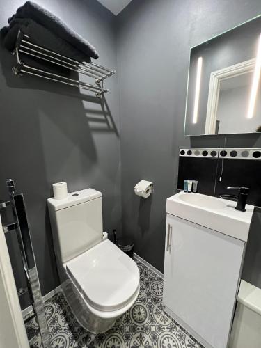 a bathroom with a white toilet and a sink at Addison House in Woking