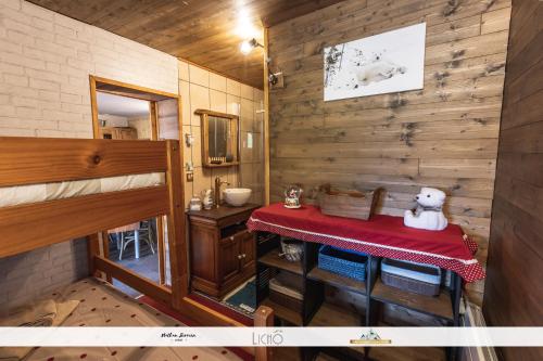 um pequeno quarto com uma mesa com um ursinho de peluche em Appartement dans Chalet Lout'Chi à Valfréjus em Valfréjus