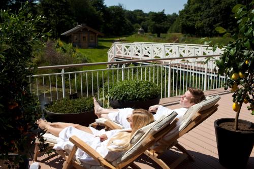 a group of people laying in lounge chairs on a deck at Romantik Hotel Waldschlösschen in Schleswig