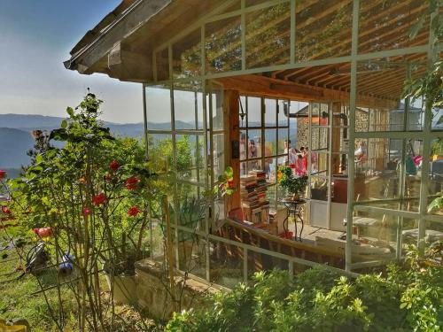a glass house with flowers and people in it at b&b LATORDICELLA in Castel del Rio