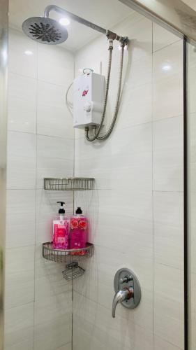 a bathroom with a shower with a shelf with toiletries at The Wind Escape Netflix-Ready Staycation for 4 in Tagaytay