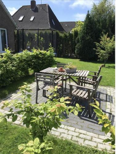 een picknicktafel en een bank in een tuin bij Ferienwohnung Gödde in Butjadingen