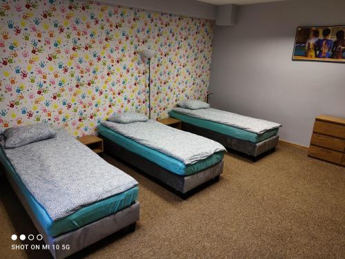 een kamer met drie bedden in een kamer bij New York apartament by Karl in Radom