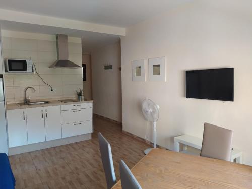 uma cozinha e sala de jantar com uma mesa e uma televisão em apartamentos la villa 3 em San Sebastián de la Gomera