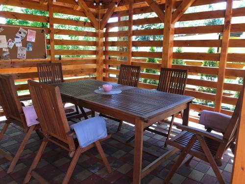 a wooden table and chairs on a patio at Boró Apartman in Tiszafüred