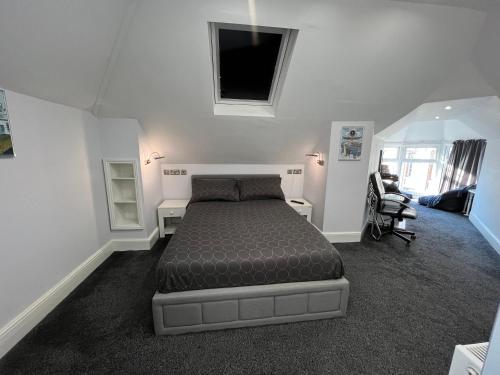 a bedroom with a bed and a chair in it at Addison House in Woking