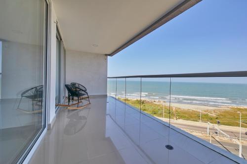 a room with a balcony with a view of the ocean at Artsy Oceanview Condo W Incredible Rooftop Pool in Cartagena de Indias
