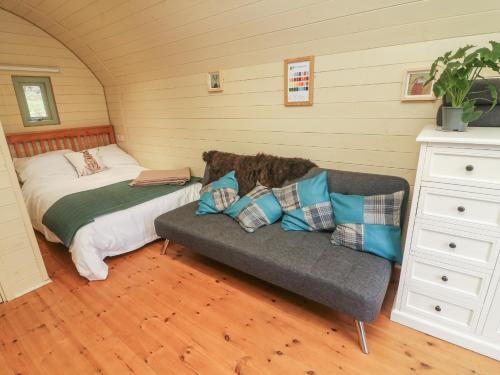 1 dormitorio con cama y sofá en Hare en Keighley