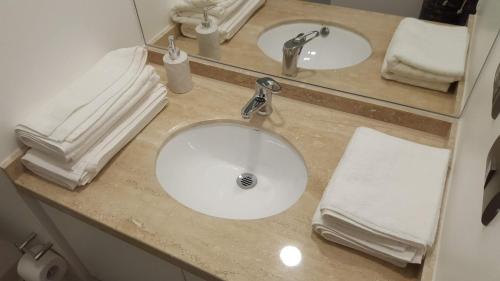a bathroom counter with two sinks and towels at Departamento costanera vista al río y con la mejor ubicación de la ciudad in Valdivia