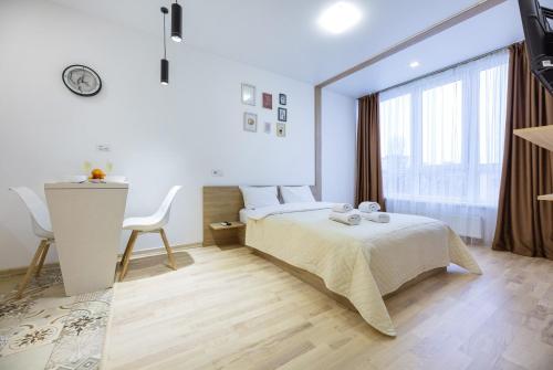 a bedroom with a bed and a desk and a window at Nyvky Like Home - Studio - apt 40 apt 46 in Kyiv