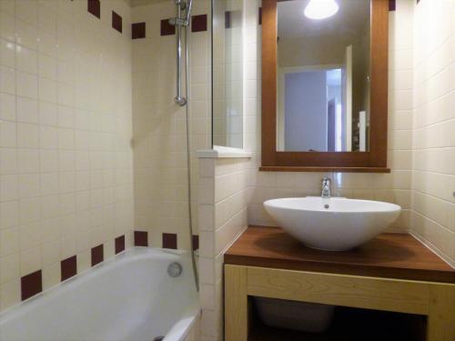 La salle de bains est pourvue d'un lavabo, d'une baignoire et d'un miroir. dans l'établissement LE HAMEAU DES VAGUES 4-5 PERS Piscines et Nature à MOLIETS, à Moliets-et-Maa