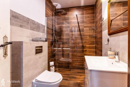 a bathroom with a shower and a toilet and a sink at Apartament w centrum Karpacza, MyWeek in Karpacz