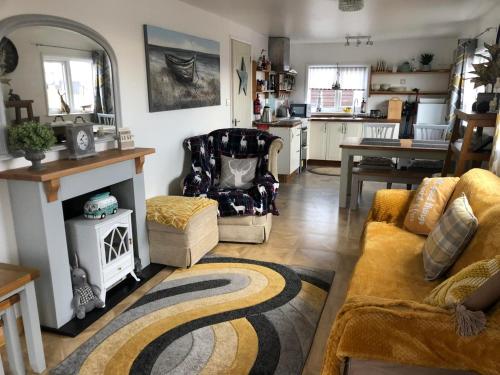 a living room with a couch and a chair and a kitchen at SunKist Lodge in Bridlington