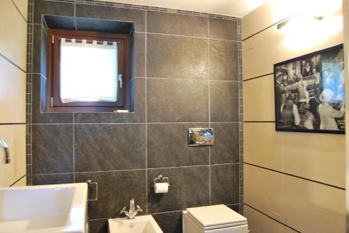 a bathroom with a toilet and a window at B&B Casa Val in Quincinetto