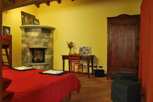 a bedroom with a red bed and a fireplace at B&B Casa Val in Quincinetto