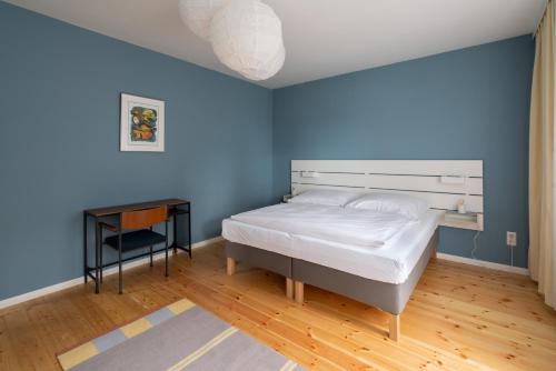 a blue bedroom with a bed and a table at 80 Quadratmeter Komfortzone in Braunlage