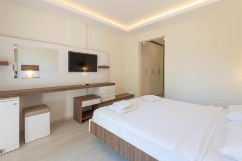 a white room with a bed and a tv at Soothe Hotel in Kalkan