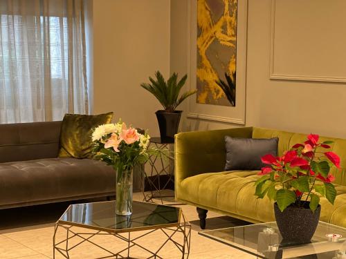 a living room with a couch and a table with flowers at Park Avenue Bayswater Inn Hyde Park in London