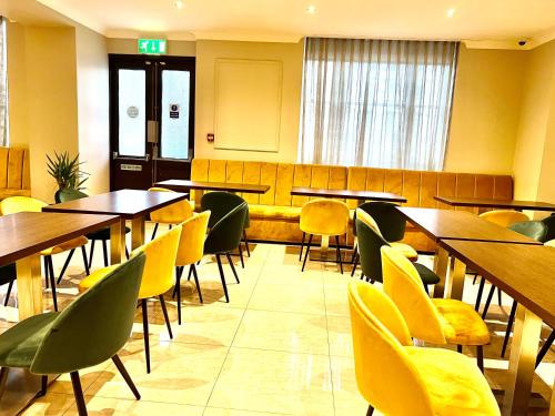 a dining room with tables and chairs in at Park Avenue Bayswater Inn Hyde Park in London