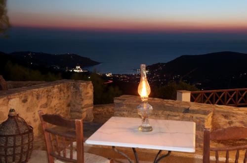a table with a candle on top of a stone wall at Voulias Αpartments in Kinion