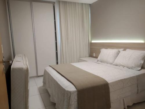 a hotel room with a bed and a window at Apartamento quarto e sala - Iloa Residence II in Barra de São Miguel