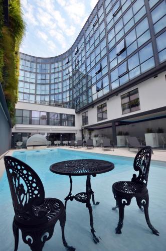 a table and two chairs in front of a pool at Holiday Inn Dijon Toison D'or by IHG in Dijon
